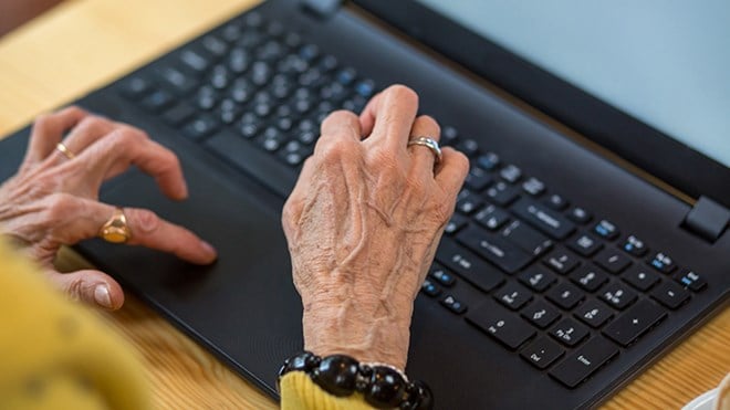 Eldre dame som skriver på PC