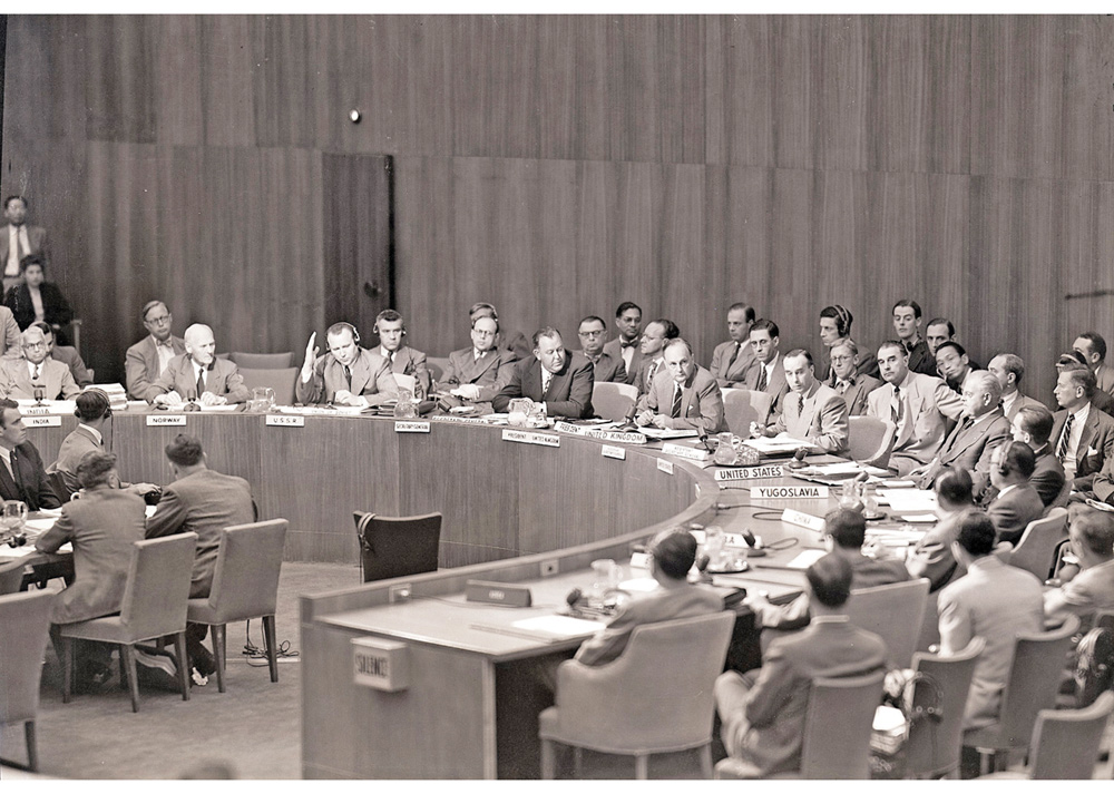 Figur 3.1 Norges FN-ambassadør Arne Sunde (til venstre i bildet) deltar i et møte i FNs sikkerhetsråd 6. september 1950, der det skulle stemmes over et amerikansk resolusjonsforslag som ba alle land om ikke å støtte koreanske kommunister. Sentralt i bildet sit...