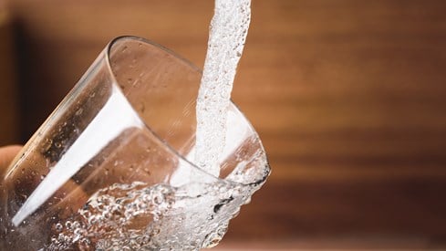 Springvann renner ned i et glass