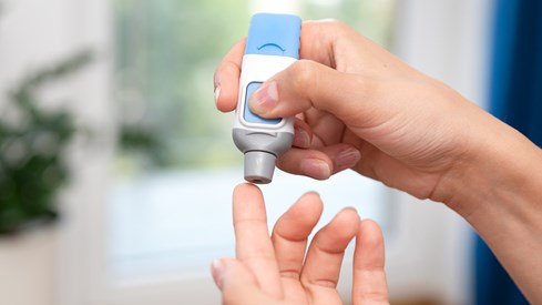 Illustrasjonsfoto av diabetesmedisin, der en finger blir stukket med et apparat