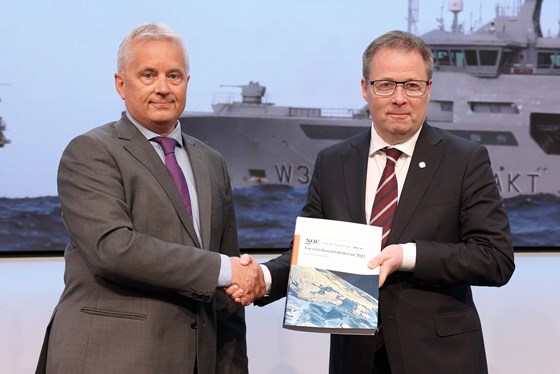 Knut Storberget gir Forsvarskommisjonens rapport til forsvarsminister Bjørn Arild Gram.