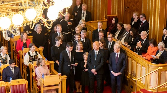 Landbruks- og matminister Geir Pollestad les Melding om Noregs rikes tilstand i Stortingssalen. Han står saman med regjeringa.