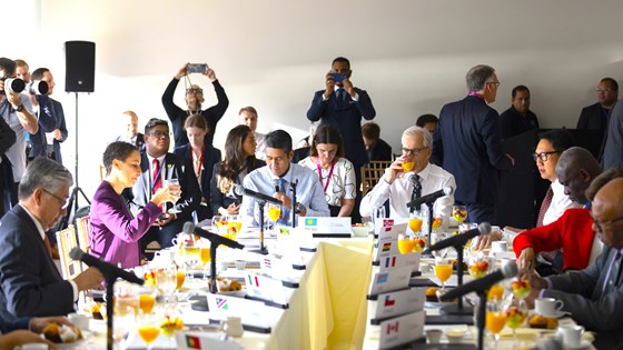 Bilde av Støre sittende ved enden av et møtebord med mange deltakere rundt.