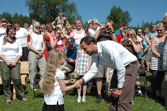 HKH Kronprins Haakon mottar bukett med seterblomster fra Vangrøftdalen og hilser på blomsterbarna Eline Grue og Håkon Eggen. Foto: LMD