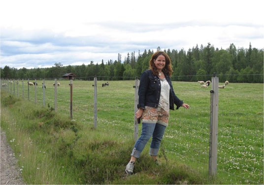 Statssekretær Heidi Sørensen ved et rovdyrsikret gjerde i Åmot kommune. Foto: Miljøverndepartementet.