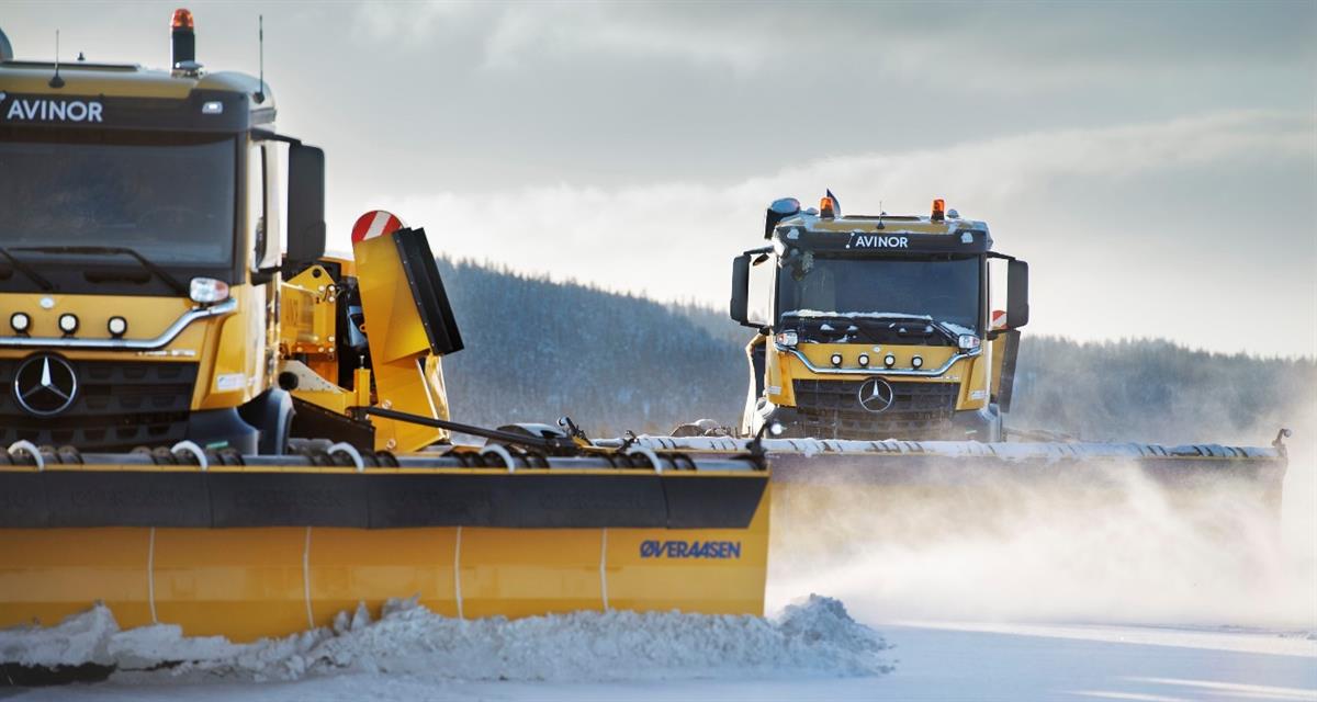 Two snow ploughs driving in formation.