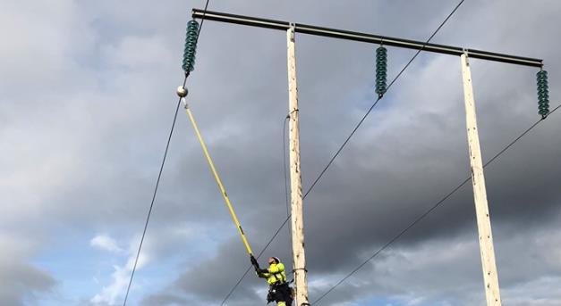 Installer checking balls with sensors on the power lines.