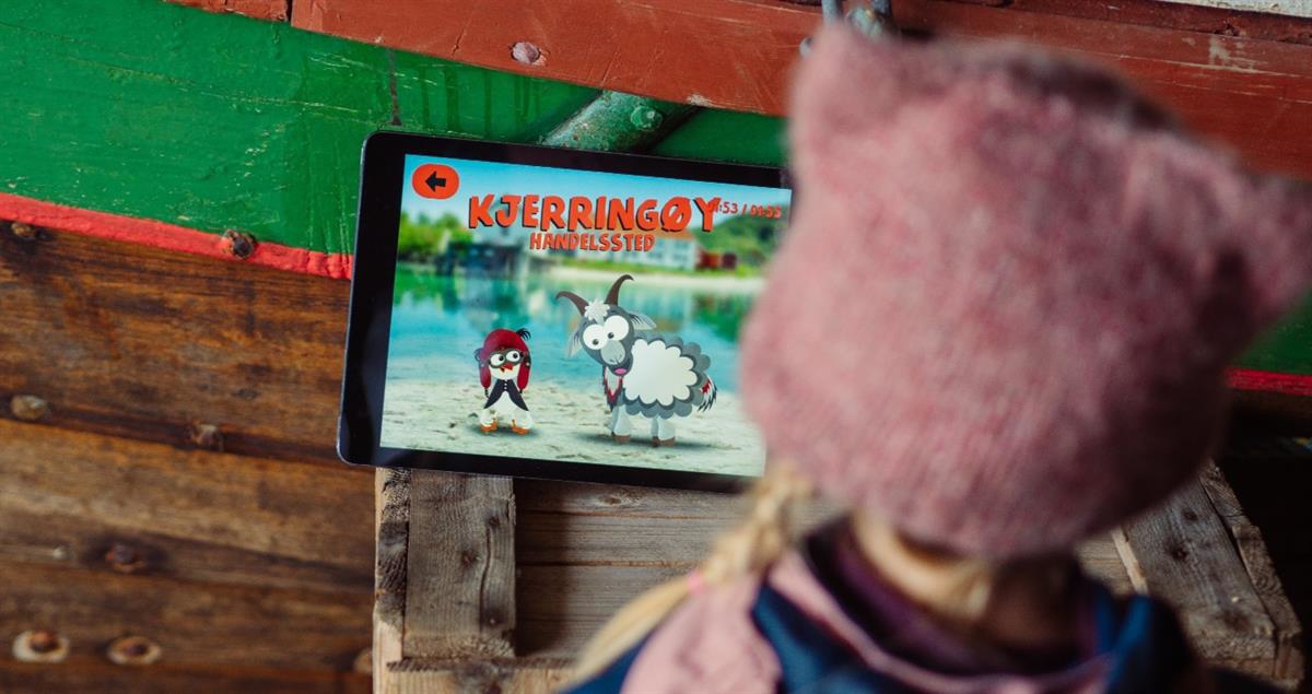 Et barn som ser på reiseguiden til Bædi og Børdi på eit nettbrett.