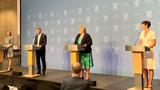 Iselin Nybø, Bent Høie, Erna Solberg og Ine Eriksen Søreide står på podiet i en pressekonferanse om korona og reiser.