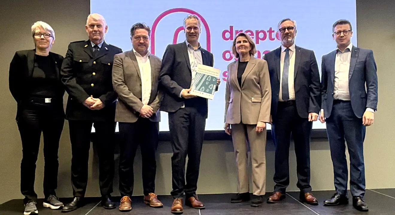 Samferdselsministeren mottar tiltaksplanen på scenen, sammen med alle aktørene som har bidratt.