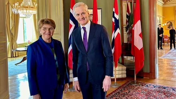 Sveits’ president Viola Amherd  og statsminister Jonas Gahr Støre står sammen foran sveitsiske og norske flagg.