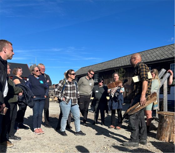 Bygningsvernsenteret på Røros. Folk som står og lytter.