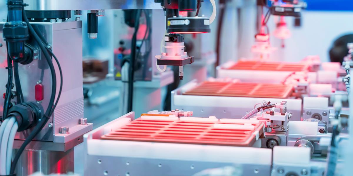 Bilde av automatiserte maskiner i en fabrikk.