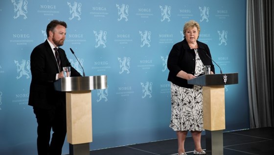 Torbjørn Røe Isaksen og Erna Solberg på scenen foran en blå pressevegg på Statsministerens kontor