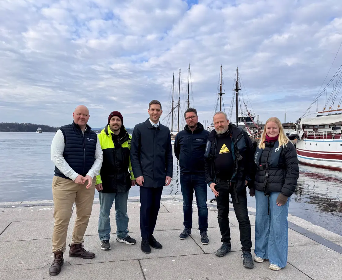 Seks personer på Honnørbrygga i Oslo. Båter i bakgrunnen.