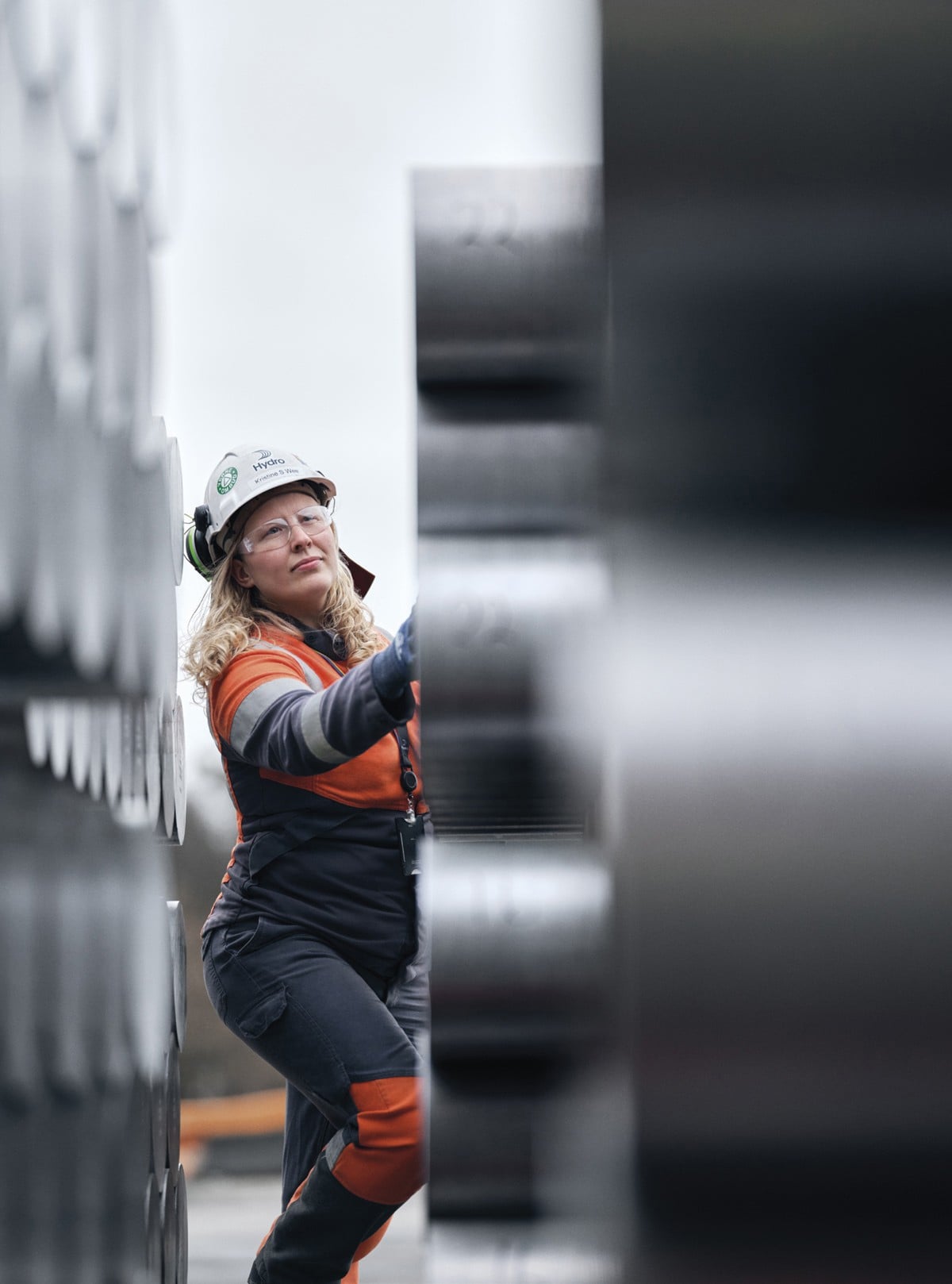 En arbeider inspiserer rørinstallasjoner i et industrimiljø.