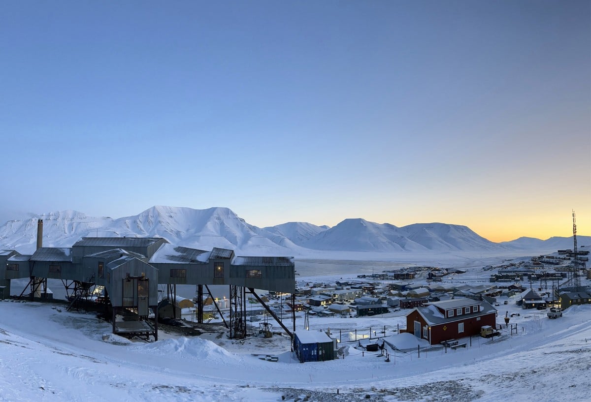 Longyearbyen på Svalbard, med snødekt landskap i bakgrunnen.