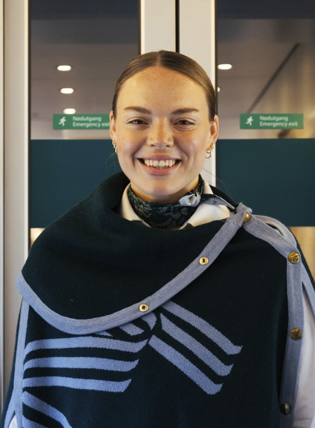 En smilende kvinne jobber om bord på et Vy-tog.