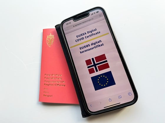Bildet viser et norsk pass og en mobiltelefon med digitalt koronasertifikat.
