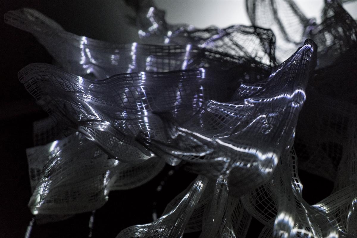 Progress by the Japanese artist Akinori Goto. A curly mesh of conducting material glowing in the shapes of humans. Used with permission from Ars Electronica and Design society.