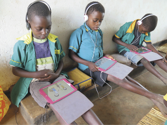 Figure 5.1 Pupils in a school in Njewa just outside Lilongwe, Malawi, concentrating on drawings and numbers on tablets.
