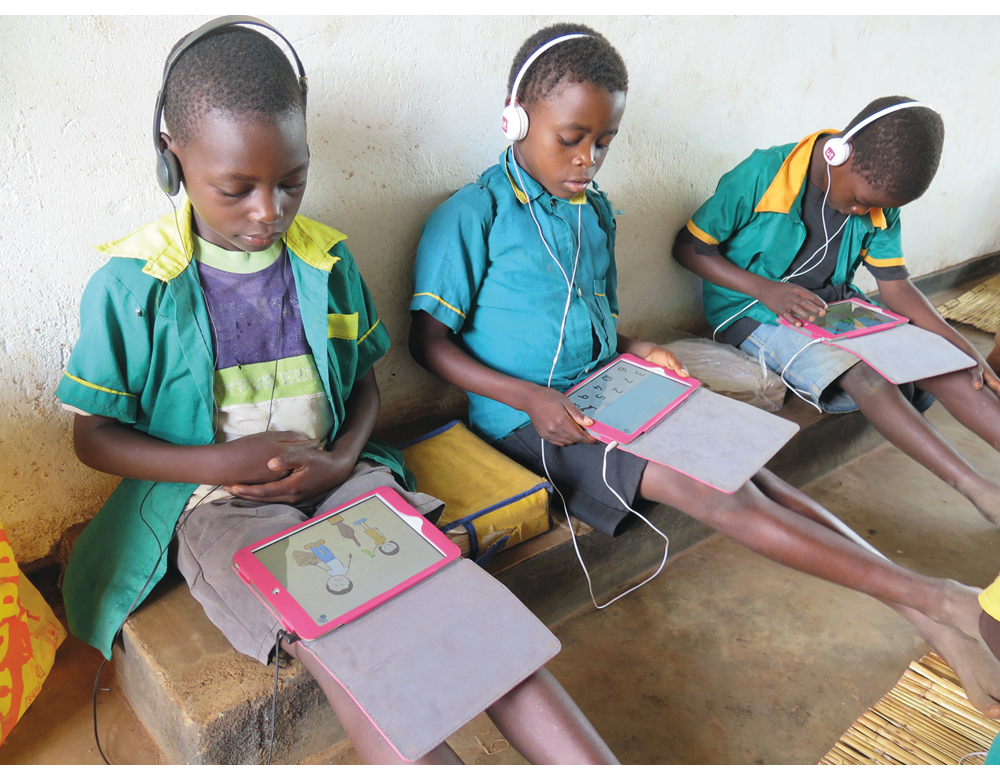 Figur 2.4 De er intenst opptatt med figurer og tall på lesebrettet, elevene på skolen i Njewa utenfor Lilongwe i Malawi.
