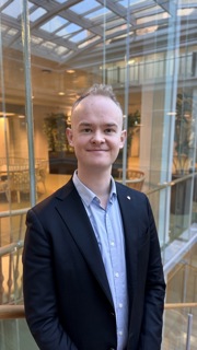 Statssekretær Kristoffer Hansen står i lokalene til Klima- og miljødepartementet