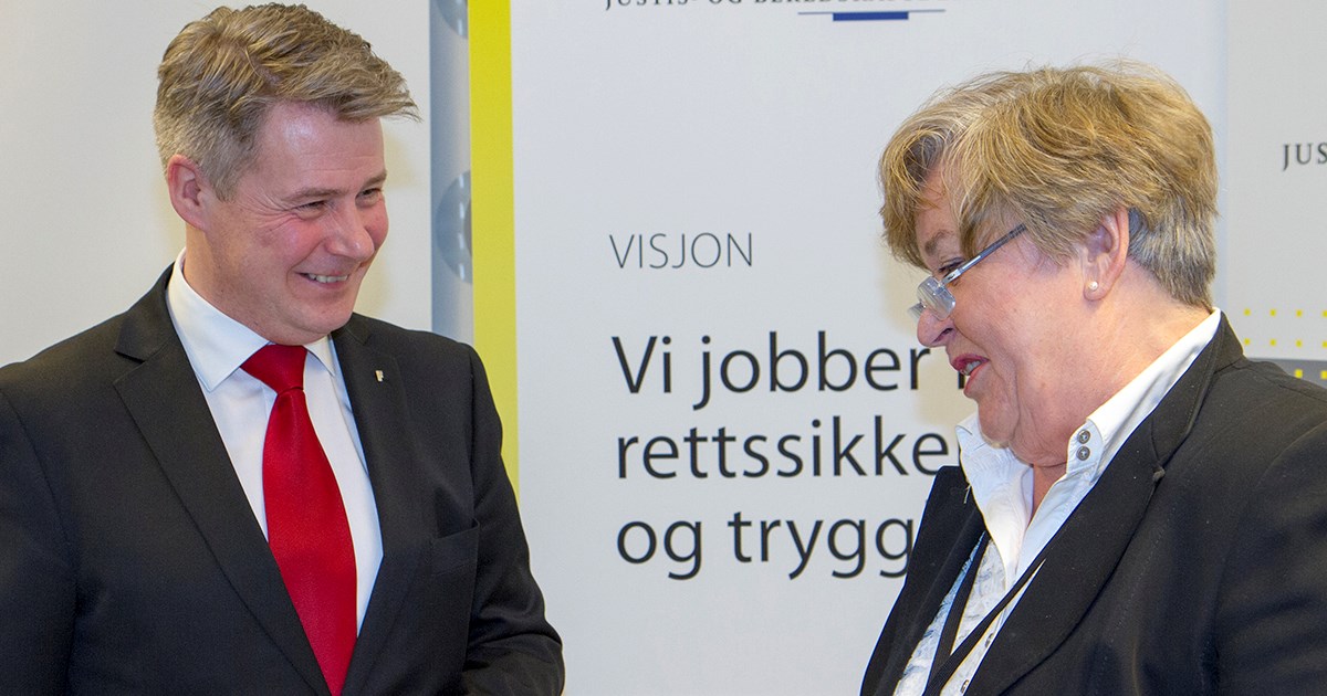 Justis- og beredskapsminister Per-Willy Amundsen og Bevæpningsutvalgets leder Anne Kari Lande Hasle ved overleveringen av NOU-en