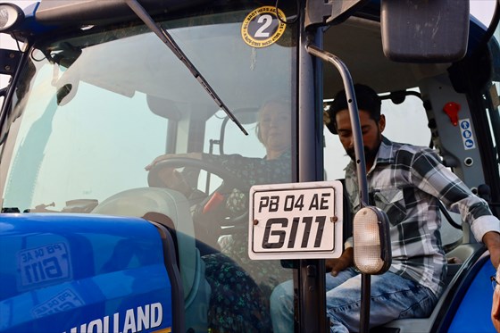 Bilde av utviklingsministeren som sitter innie i en blå traktor, sett forfra