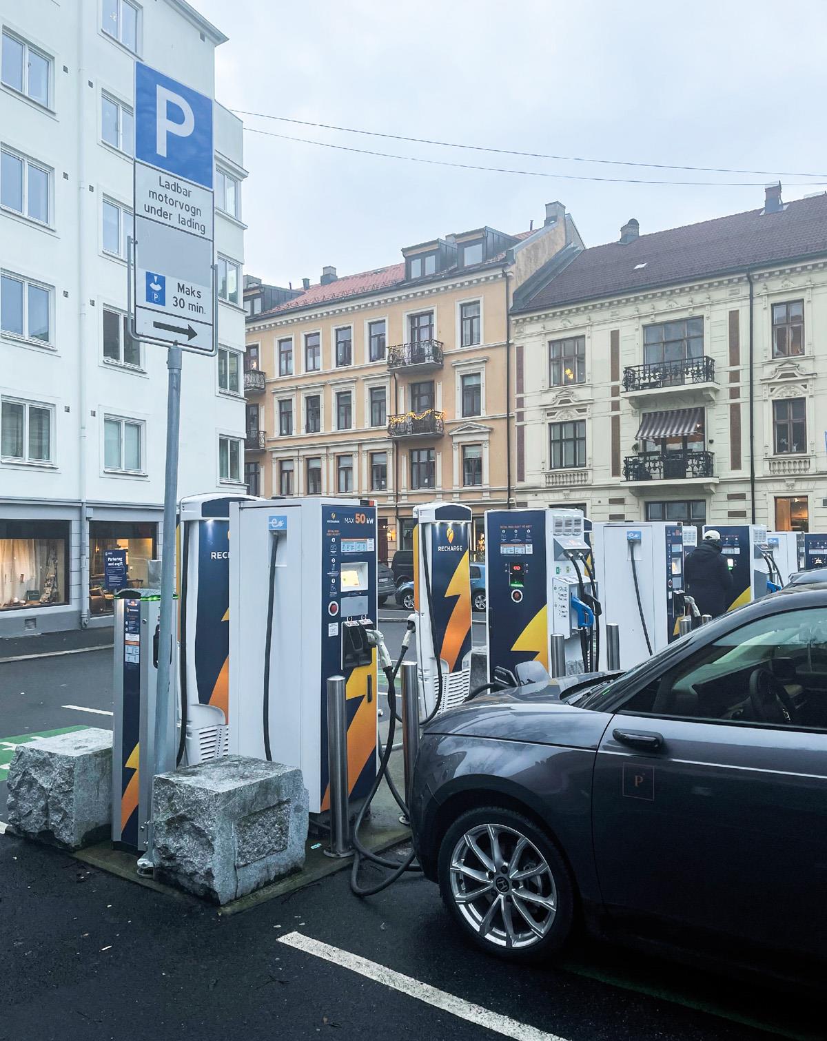 Foto av parkeringsplasser med elbil-ladere i by.