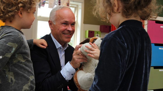 Bilde av Jan Tore Sanner som leker med barn i barnehage