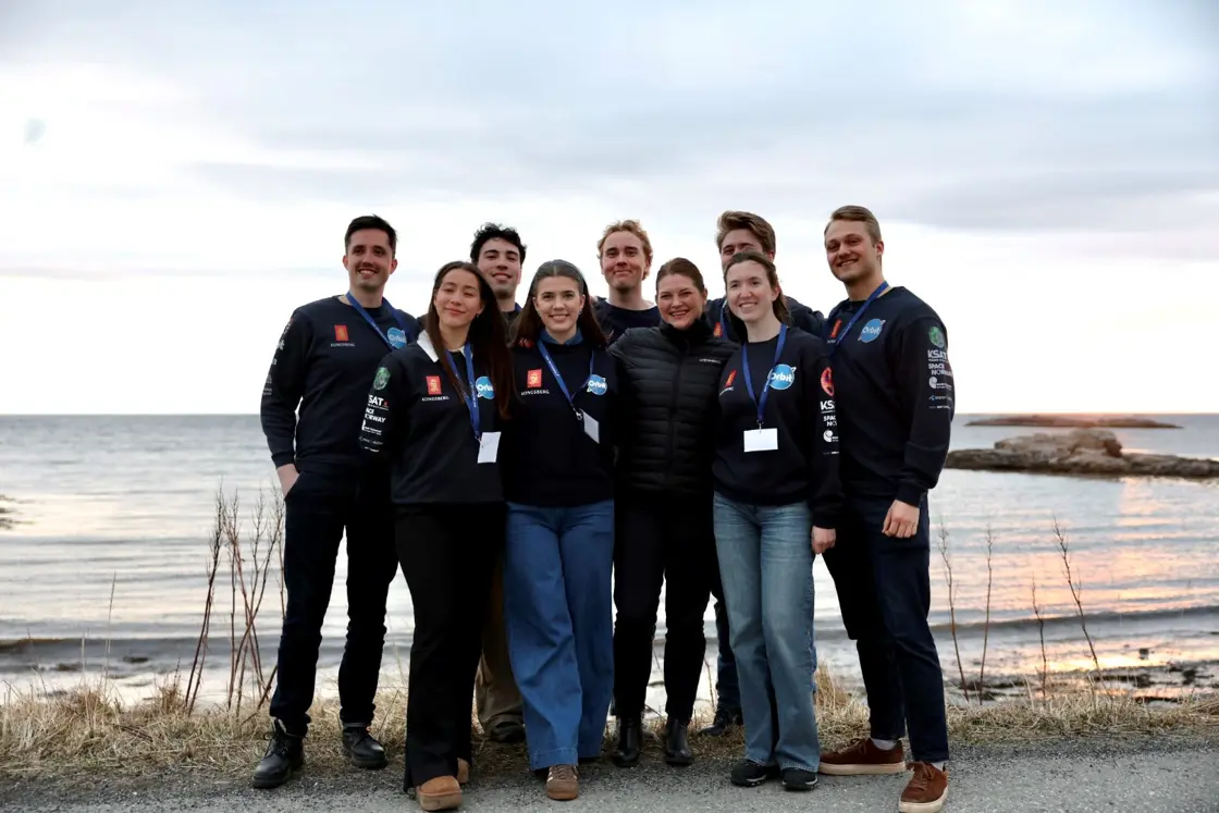 Næringsministeren sammen med studentene i solnedgangen før oppskytingen.