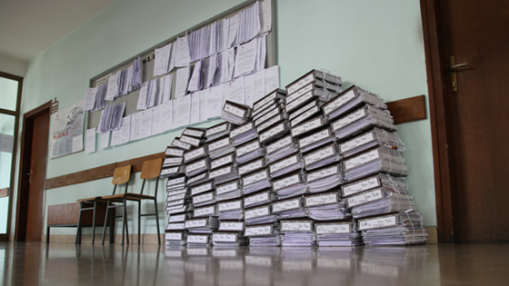 Høye stabler med mapper og papirer på et offentlig kontor. 