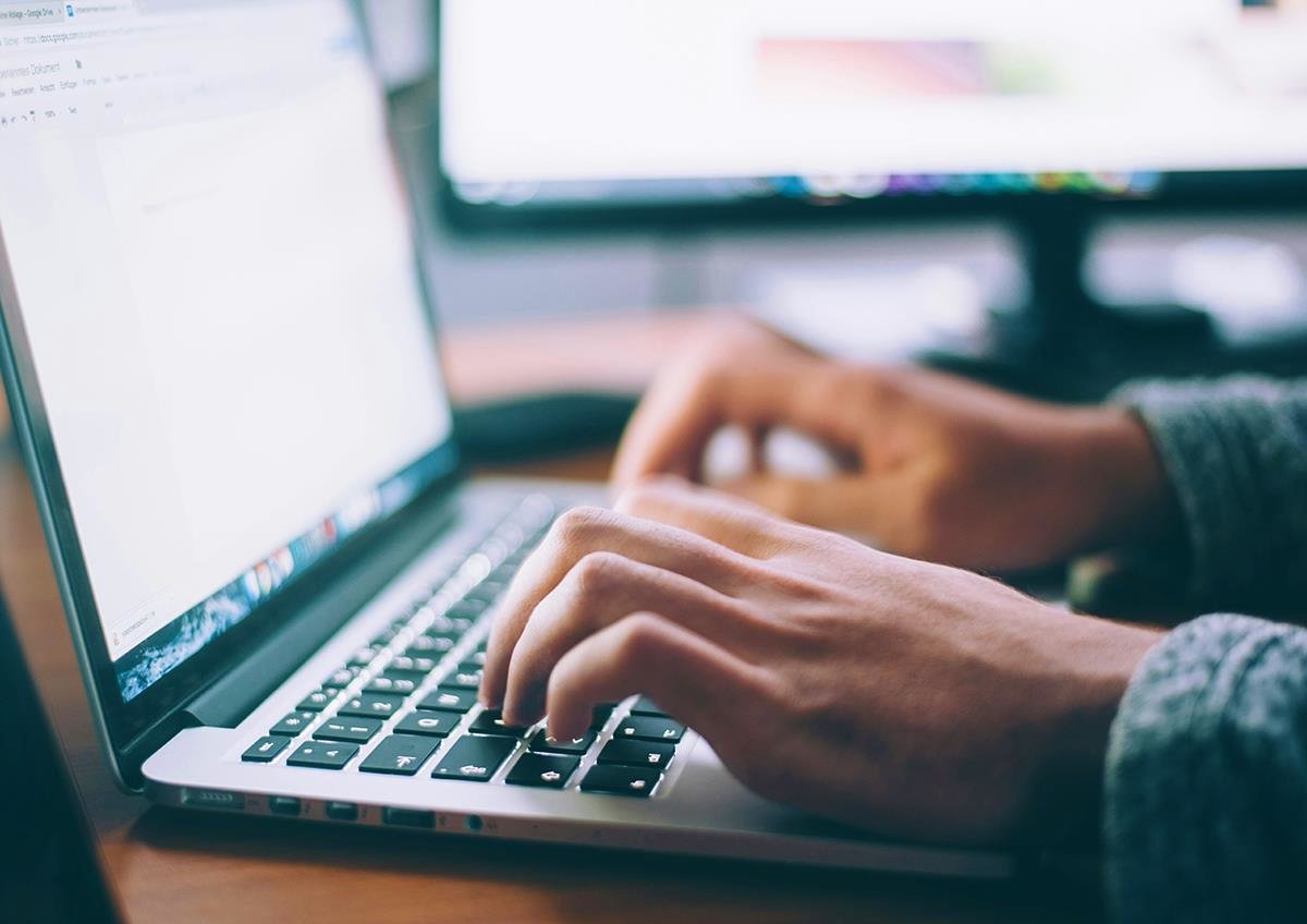 Bilde av en person som skriver på et tastatur til en bærbar PC.