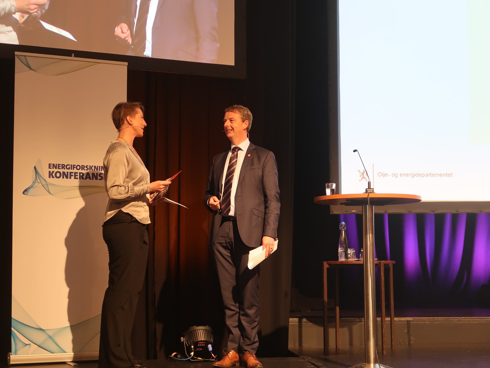Olje- og energiminister Terje Søviknes takkes av med en sollampe, overrakt av moderator  Ruth Astrid L. Sæter fra Forskningsrådet 