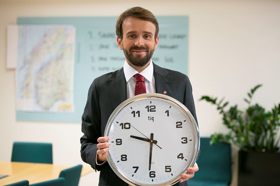 Næringsminister Jan Christian Vestre holder opp en klokke
