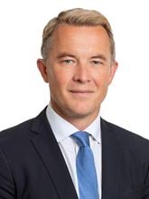 Bilde av statssekretær Andreas Motzfeldt Kravik i mørk dress med slips