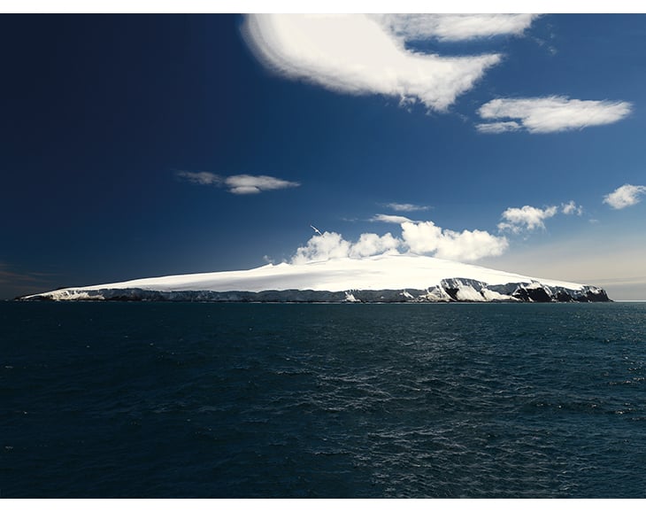 Figur 2.1 Bouvetøya regnes som den mest avsidesliggende øya i verden. Den er som oftest innhyllet i skyer eller tett tåke. Her er Bouvetøya fotografert på en sjelden klarværsdag.