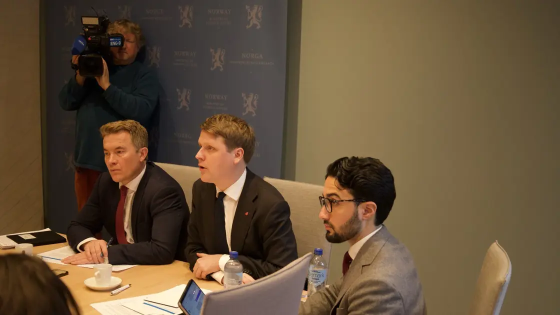 Menn som sitter rundt et møtebord