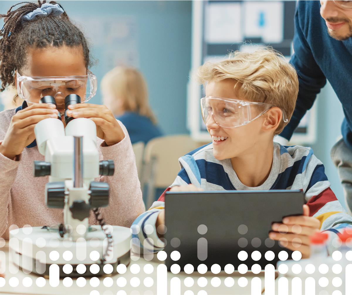 foto av to barn og lærer som arbeider i klasserom med nettbrett og mikroskop