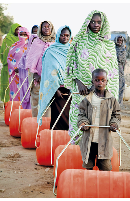 Figure 4.4 Internally displaced people in a camp in El Faser, Darfur, wheeling water containers.