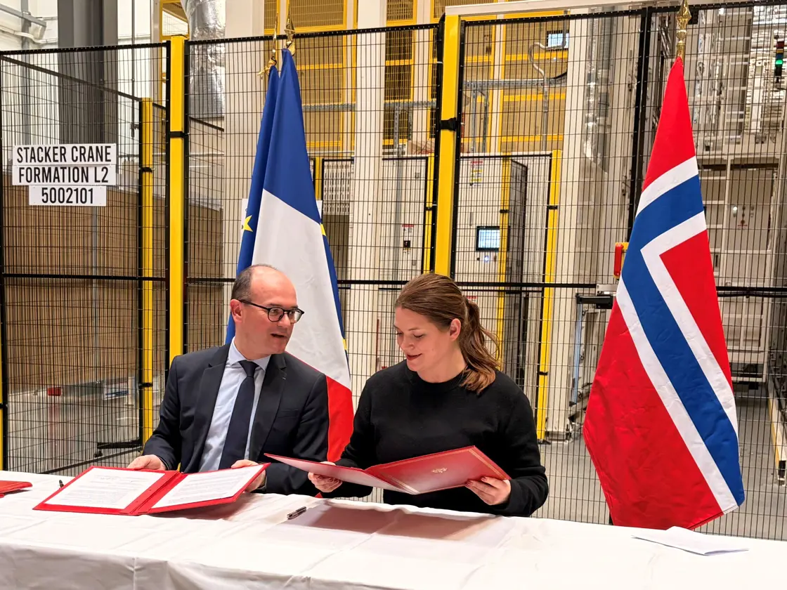 Den franske industriministeren Sébastien Martin og næringsminister Cecilie Myrseth sitter ved et bord med det franske og det norske flagget bak seg, i ferd med å signere erklæringen.