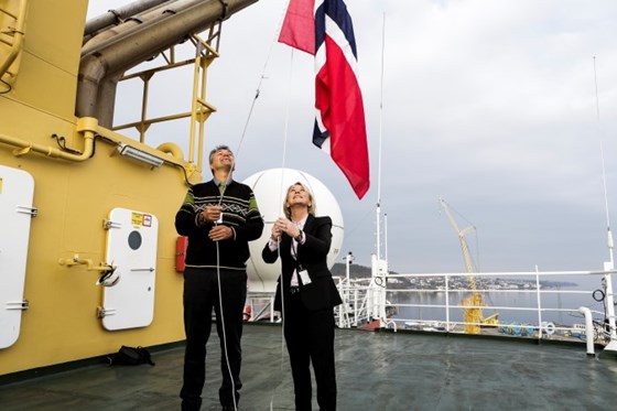 Næringsminister Monica Mæland og sjøfartsdirektør Olav Akselsen heiser flagg ombord på båt.