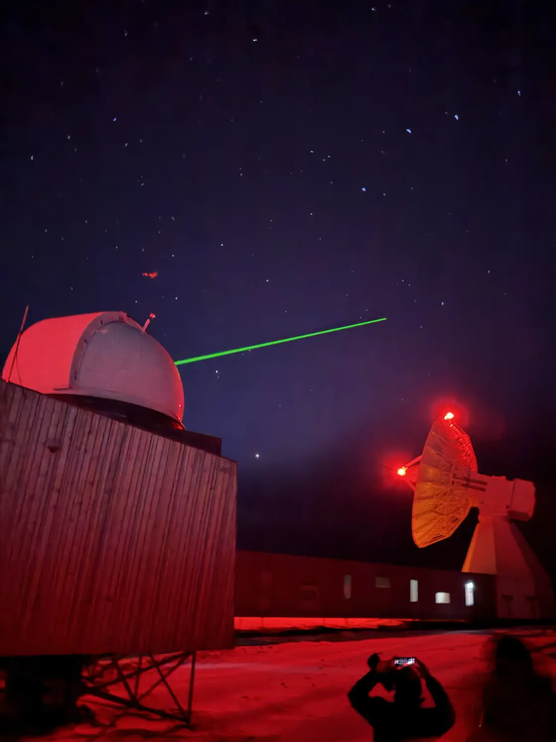 Bilde av satellittavstandsmåler med grønn laser som måler avstand til satelitter