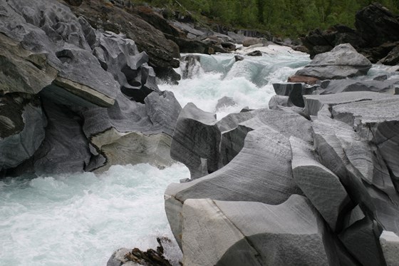 En stri elv renner forbi steiner som ligner marmor
