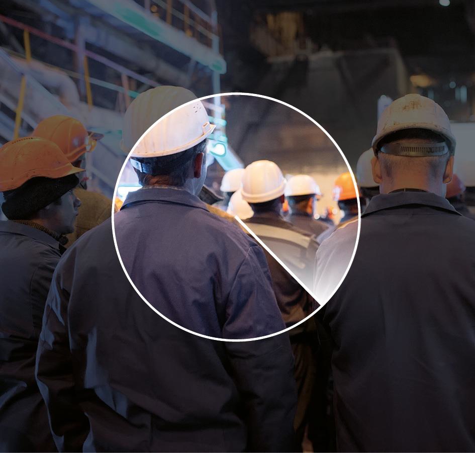 The picture shows workers in protective gear walking inside the workplace.