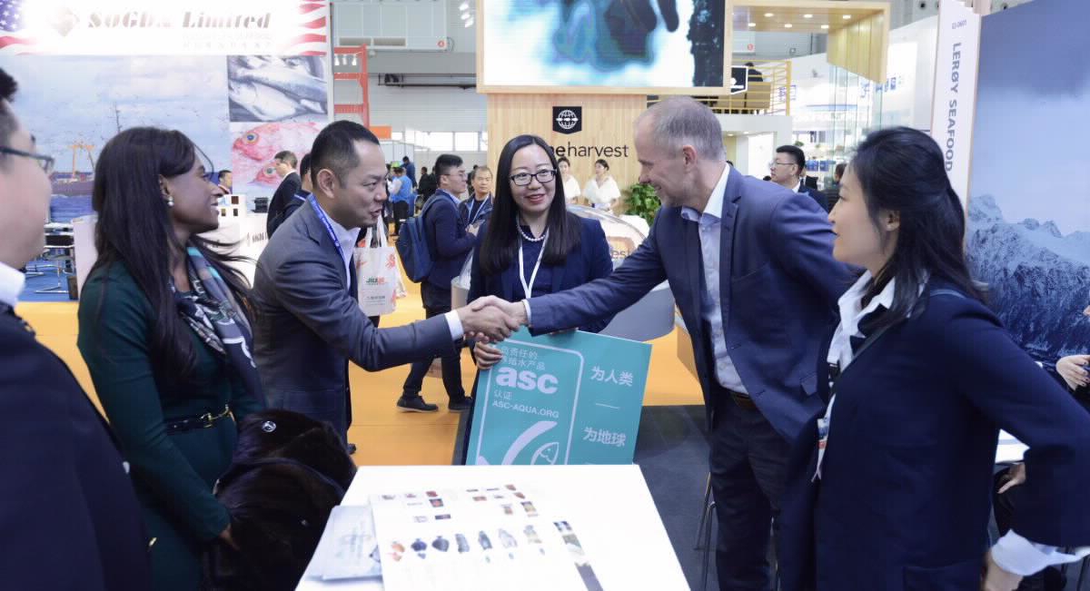 A group of people shaking hands on a deal at an international seafood