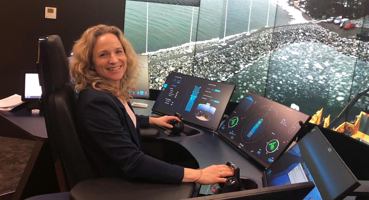 Woman working in front of digital instruments in a control room for autonomous vessels.