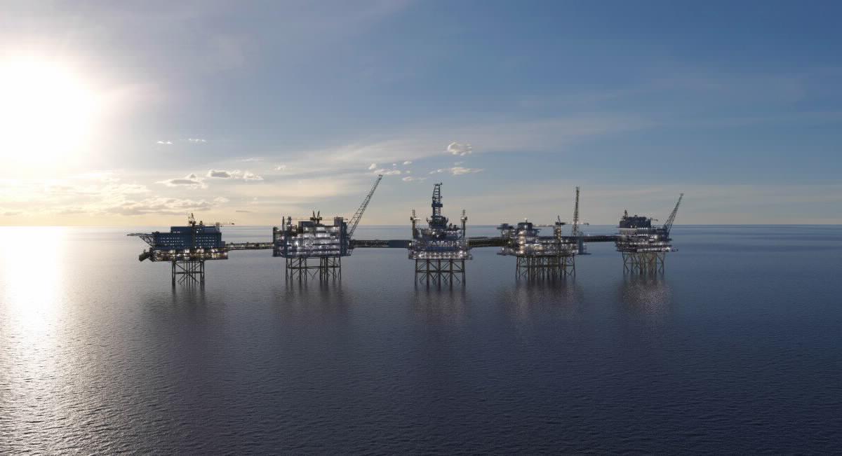 Et oljefelt med 5 store oljeplattformer stående på rekke etter hverandre i sjøen.