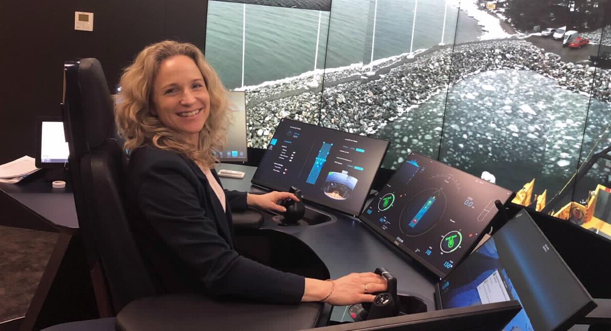 Kvinne som jobber foran digitale instrumenter i et kontrollrom for fjernstyring av autonome skip.